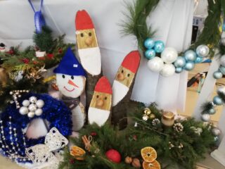 Stoisko z stroikami świątecznymi i krasnalami wykonanymi z drewna