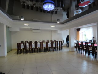 Duża sala z dwoma długimi stołami. Dużo wolnej przestrzeni.