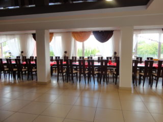 Duża sala z bardzo długim stołem z krzesłami. Dużo wolnej przestrzeni.