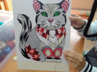 Obrazek który przedstawia kota. Obrazek jest zrobiony z nici.