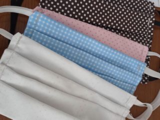 Cztery materiałowe maseczki w różnych kolorach.