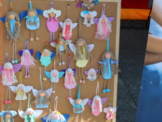 Ręcznie robione aniołki zawieszone na tablicy.