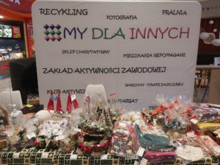 Stoisko z ozdobami bożonarodzeniowymi na tle tablicy My dla innych.