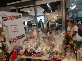 Stoisko z ozdobami świątecznymi takimi jak kubki, bombki, choinki, ozdoby z martwej natury, domki z piernika.