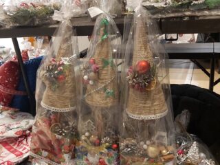 Ozdoby świąteczne takie jak małe choinki ze sznurka, świeczki i wieńce z martwej natury,