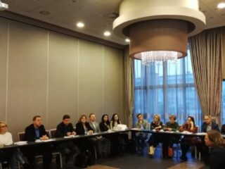 Spotkanie Regionalnego Komitetu Ekonomii Społecznej w hotelu 3 Trio. Uczestnicy spotkania siedzą przy ścianach przy długich łączonych stołach.