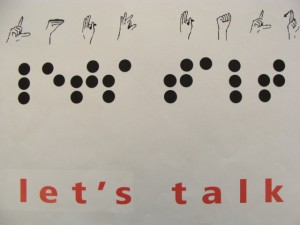 Grafika z napisem w trzech językach - migowy, braillem oraz angielskim.